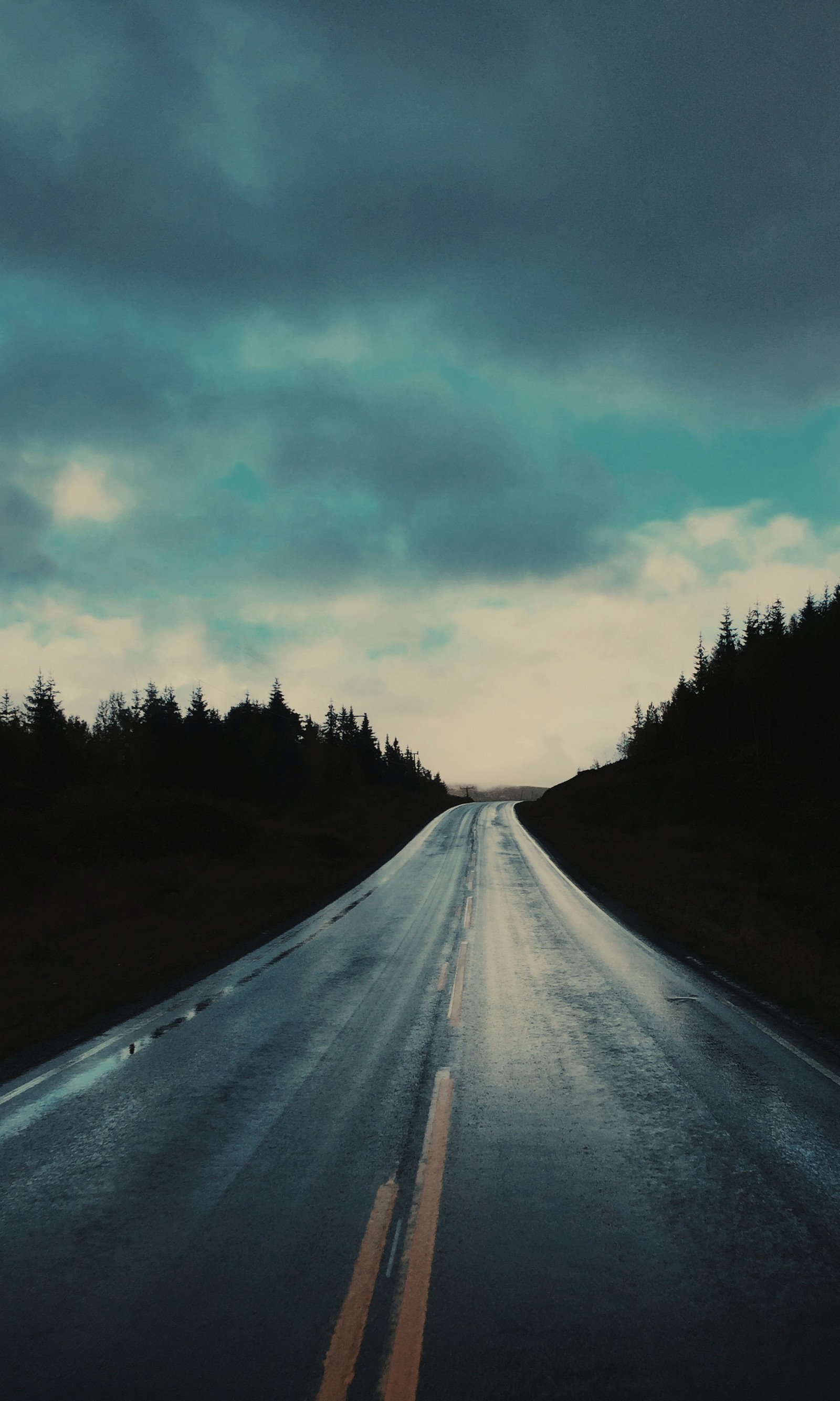 Il y a une longue route avec une ligne jaune sur le côté (nuages, sombre, hd, autoroute, nature)