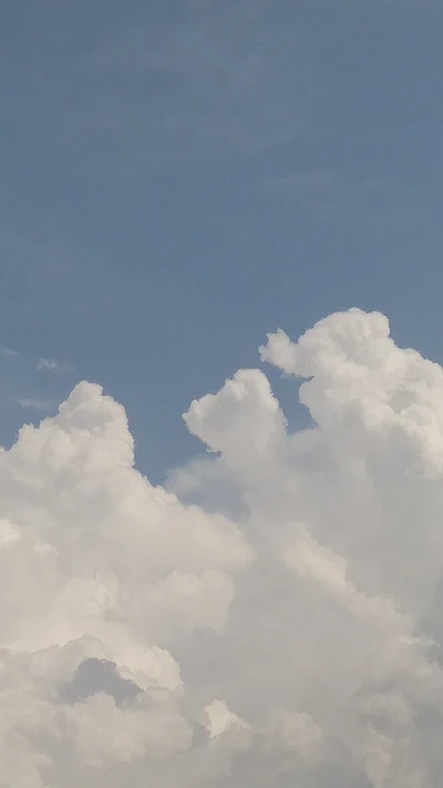 Flauschige weiße Wolken gegen einen klaren blauen Himmel