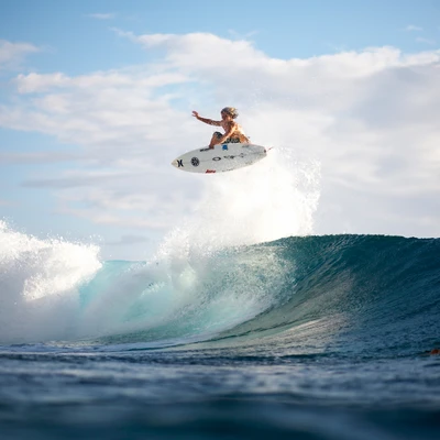 Surfer Leaping Above Waves