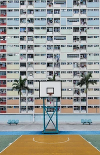 Terrain de basket urbain entouré d'une façade de condominium colorée