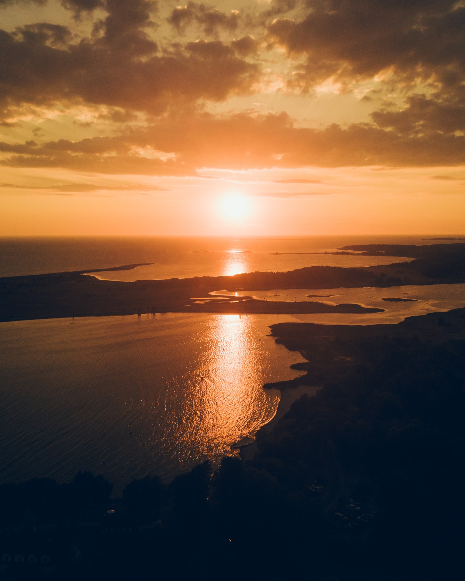 Vue panoramique d'un coucher de soleil sur un plan d'eau (coucher de soleil, horizon, lever de soleil, crépuscule, eau)