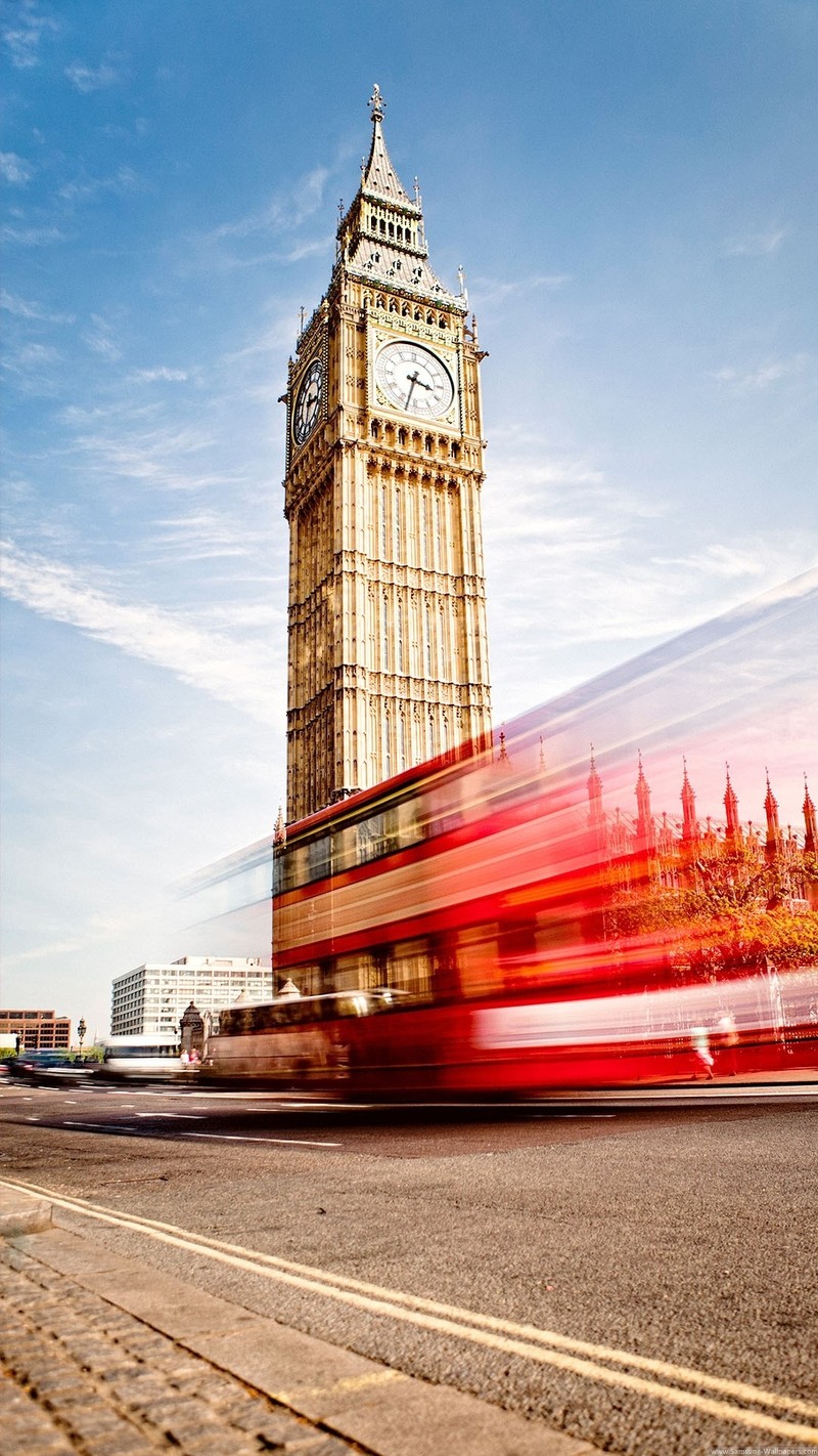 Вид на красный автобус, проезжающий мимо часовой башни (биг бен, big ben, часы на башне, башня, облако)