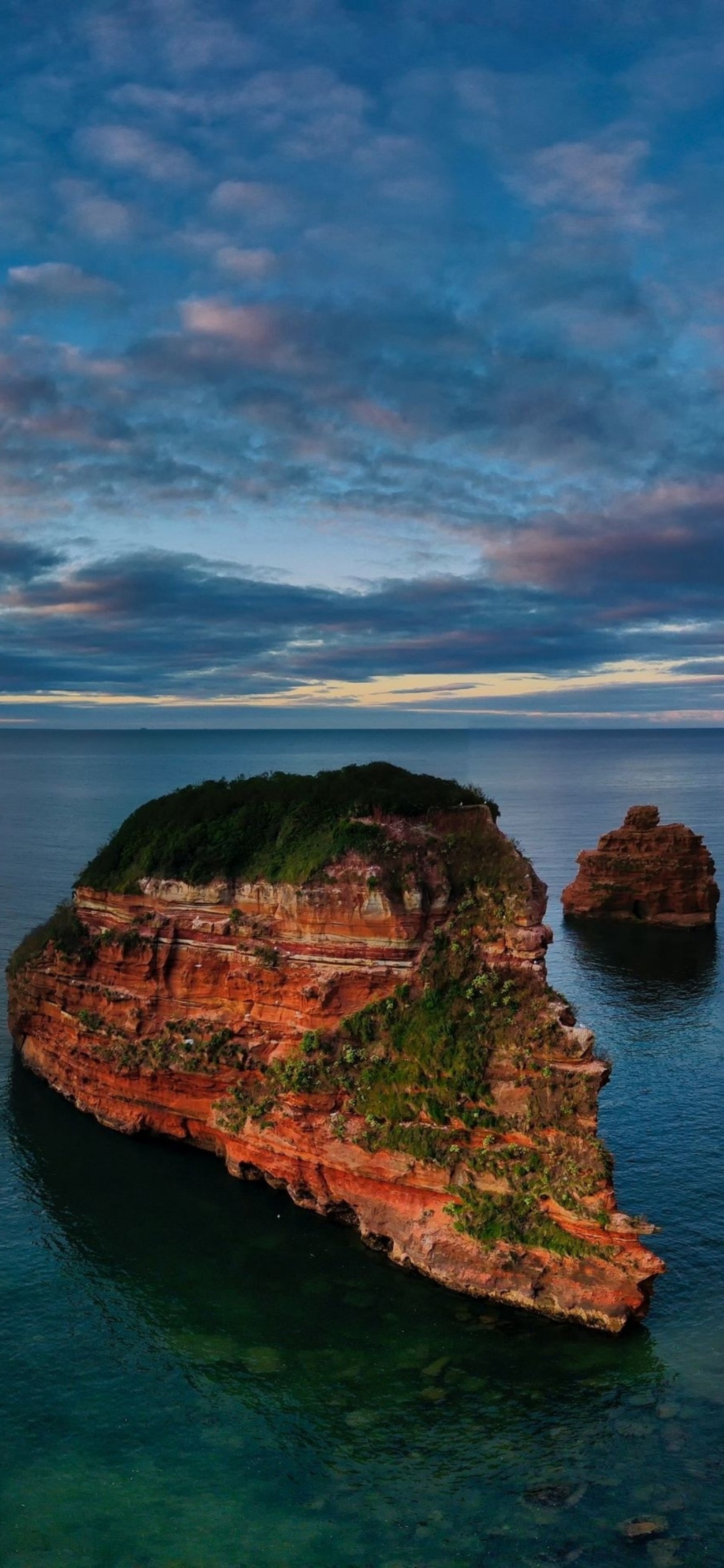 Image parfumée d'une formation rocheuse dans l'océan avec un ciel nuageux (paysage naturel, roche, eau, la côte, île)