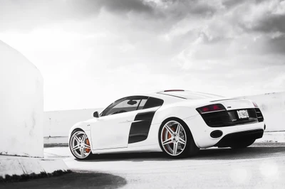 Sleek white Audi R8 showcasing its distinctive design and performance features against a dramatic sky.