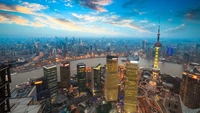 Ein atemberaubender Luftblick auf die Skyline von Shanghai, mit ikonischen Wolkenkratzern wie dem Jin Mao Tower und dem Oriental Pearl Tower, beleuchtet gegen einen lebhaften Sonnenuntergangshimmel über dem Bund und dem Huangpu-Fluss.