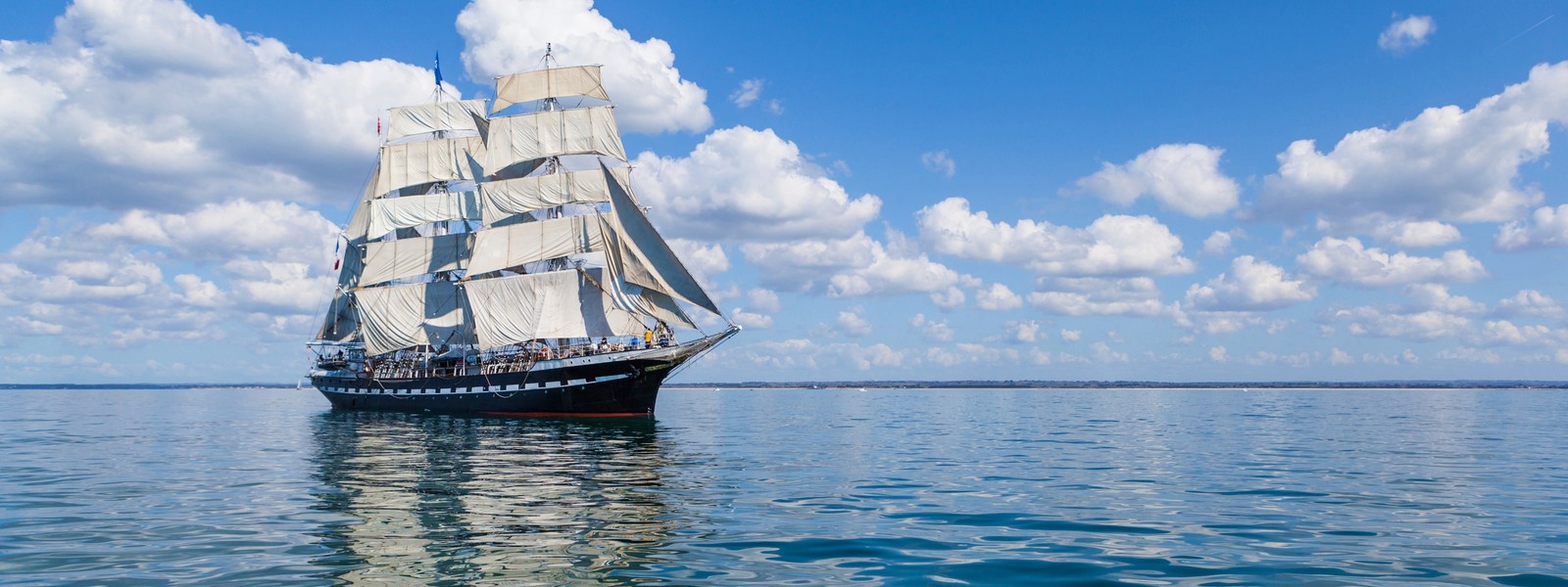 Voilier arafed dans l'océan avec des nuages en arrière-plan (schooner, navire, ciel, mer, transport aquatique)