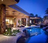 Elegante Abendansicht einer luxuriösen Villa mit einem ruhigen Pool und üppiger Landschaftsgestaltung.