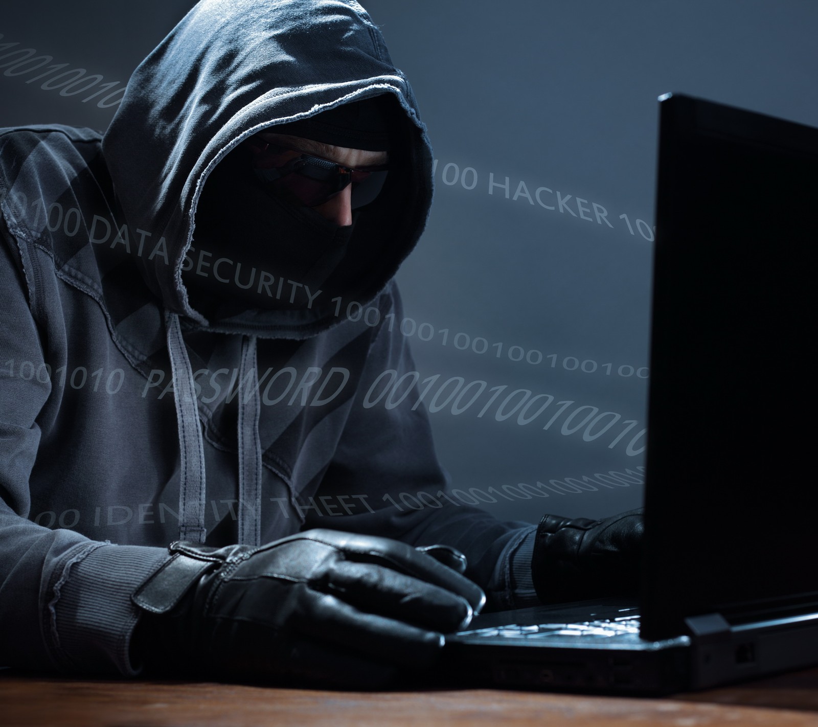 Arabischer mann in einem hoodie, der einen laptop benutzt (computer, daten, hacker, laptop, passwort)