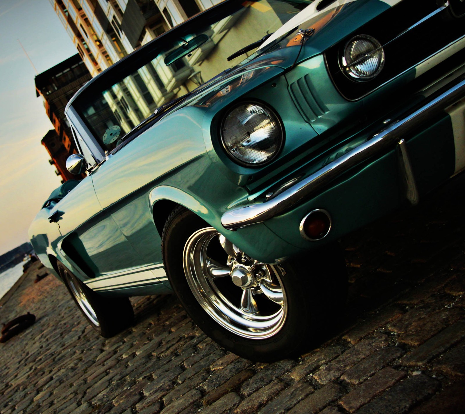 There is a green car parked on a cobblestone street (america, beauty, car, green, mustang)