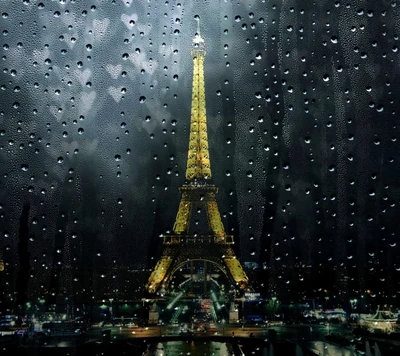 Vista nocturna romántica de la Torre Eiffel a través de vidrio cargado de lluvia