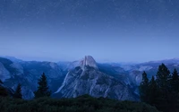 Noite estrelada sobre Half Dome no Parque Nacional de Yosemite, exibindo uma paisagem montanhosa serena e uma atmosfera de wilderness.