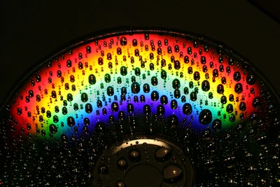 Makrofotografie einer CD, die einen Regenbogen durch Wassertropfen reflektiert