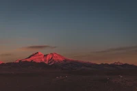 Majestätischer Schildvulkan bei Sonnenaufgang über einer weiten Tundralandschaft