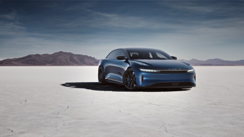 Синий автомобиль припаркован в пустынной местности с горами на фоне (lucid air sapphire, электромобили, люксовый седан, 2023, машины)