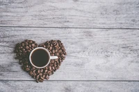 Heart-Shaped Coffee Beans Surrounding a Cup of Brewed Coffee