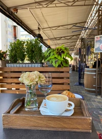 Elegante Café-Tischdekoration mit Kaffee, Blumen und Gebäck