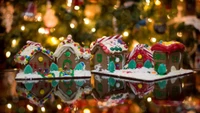 Delightful gingerbread houses adorned with colorful decorations, reflecting the warmth of Christmas lights in a festive setting.