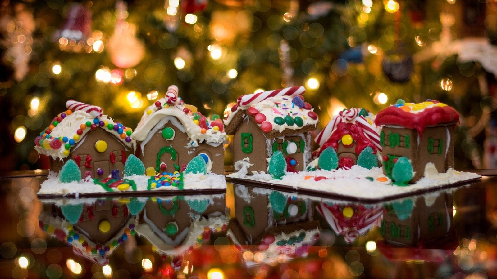 Il y a beaucoup de maisons en pain d'épice sur une table (maison en pain dépice, pain dépice, noël, décoration de noël, tradition)