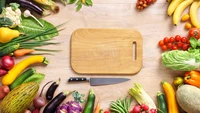 Fresh Organic Vegetables and Fruits Surrounding a Cutting Board