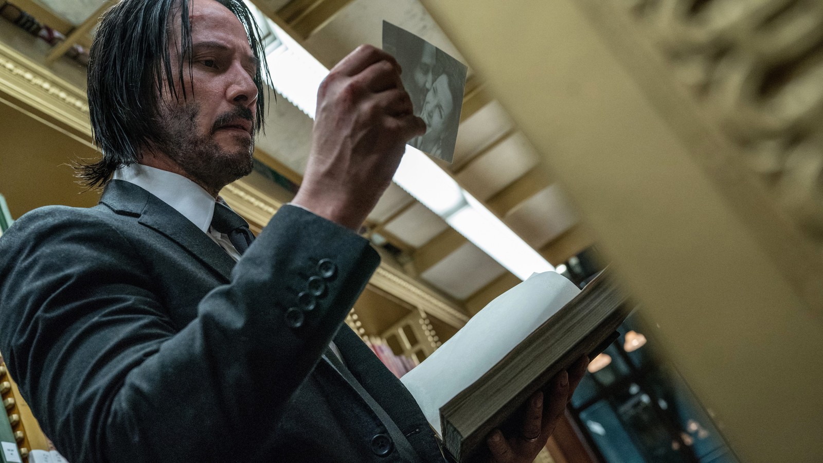 Арабский мужчина в костюме держит книгу в библиотеке (джон уик 3, john wick 3, фильм, киану ривз, keanu reeves)