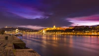 Paisaje urbano al atardecer de Budapest: reflejos en el Danubio con monumentos históricos y un horizonte vibrante.