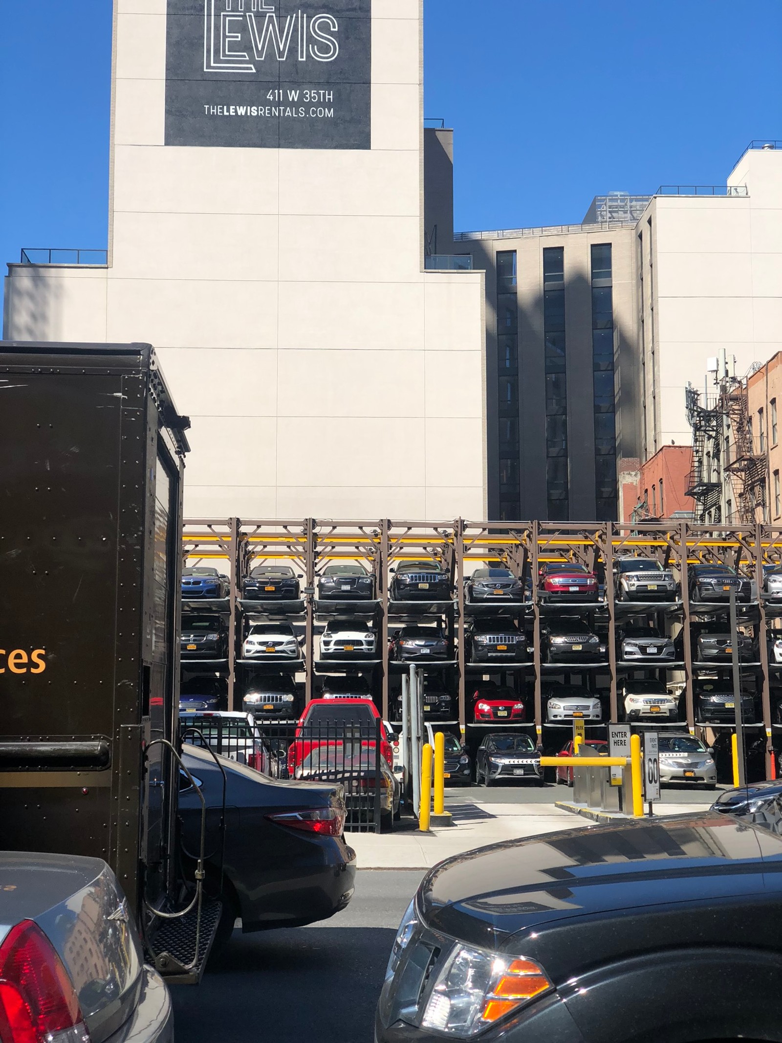 Los coches están estacionados en un aparcamiento frente a un edificio (rey, iluminación automotriz, exterior de automóvil, transporte, neumático de automóvil)