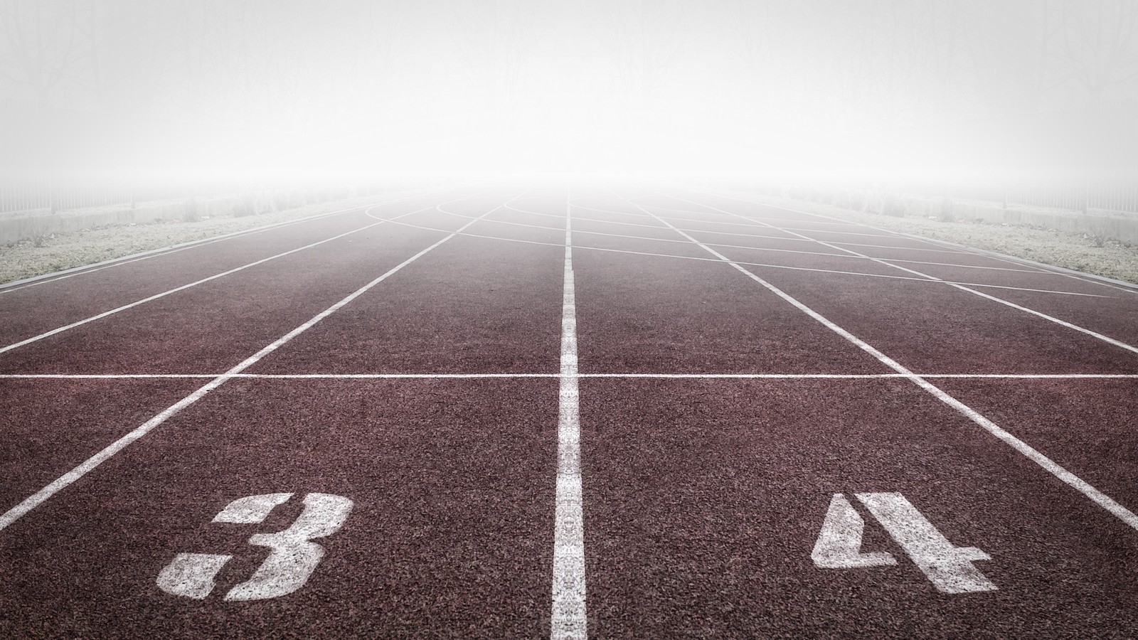 Arafed track with numbers on it in a foggy field (track and field, running, athlete, line, sport venue)