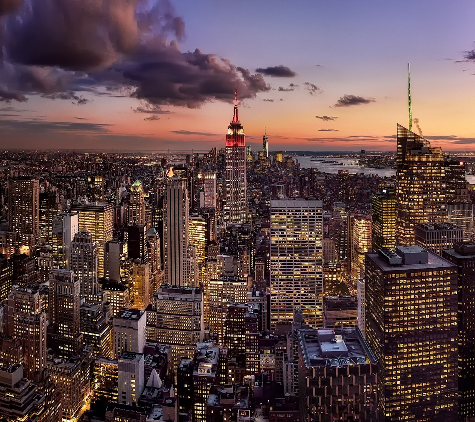 Uma vista aérea de uma cidade ao entardecer com um edifício vermelho e branco (américa, nova york, new york)