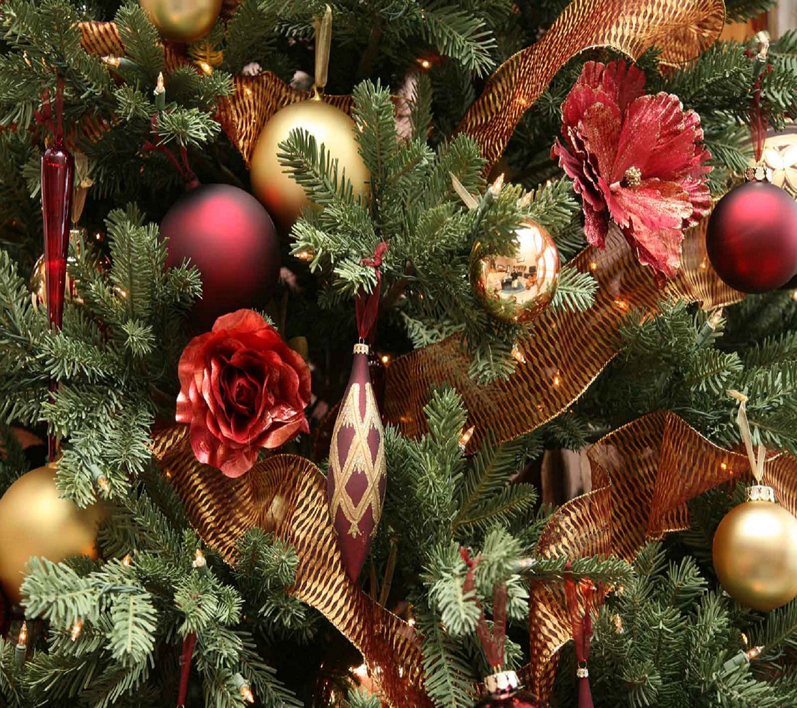 Un primer plano de un árbol de navidad con adornos y una rosa roja (navidad, decoración)