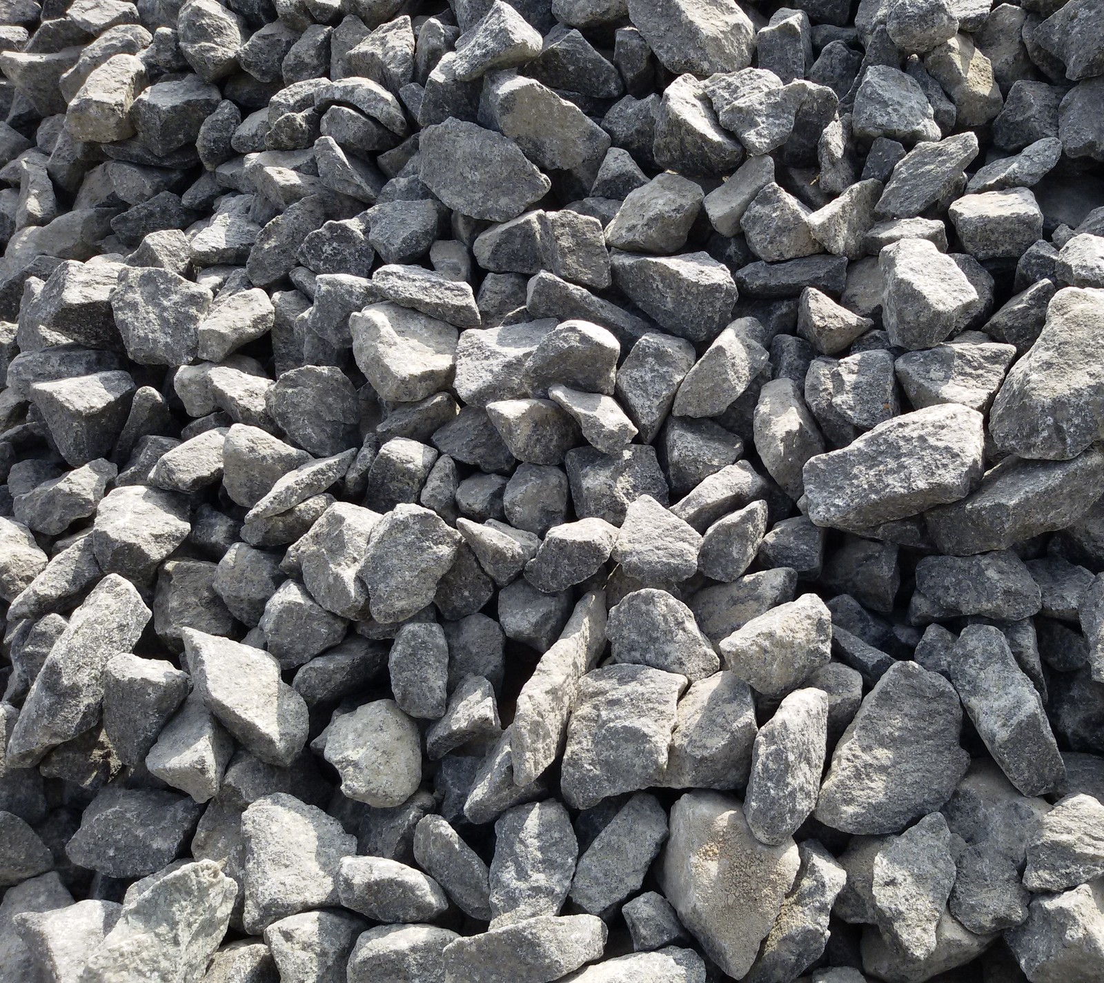 A close up of a pile of rocks with a person walking by (kamenje p, r kamenje)