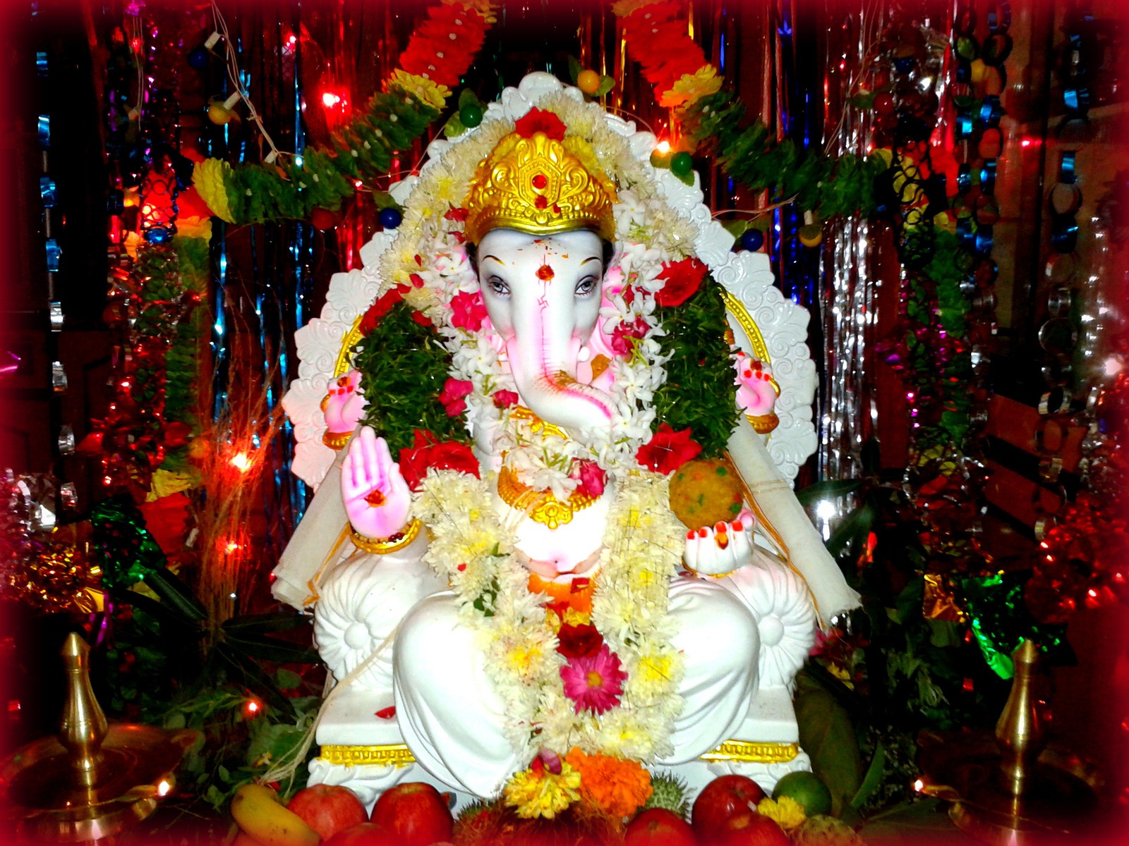 Nahaufnahme einer statue einer person mit blumen darauf (ganapati, ganesh, godganesh chaturthi, herr, sri ganesh)