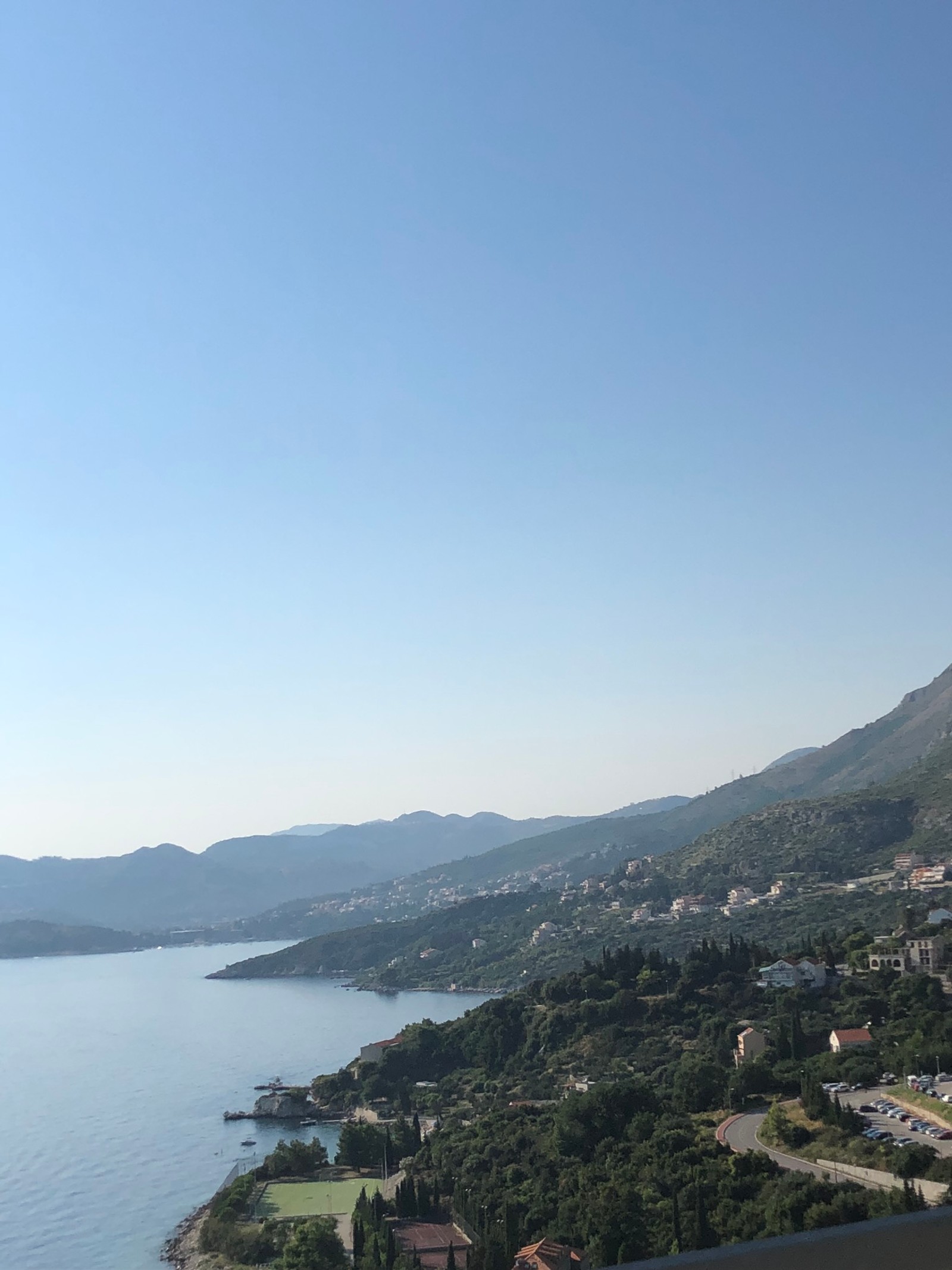 Il y a une vue sur un lac et des montagnes depuis un balcon (décor montagnard, ressources en eau, chaîne de montagnes, eau, formes montagneuses)