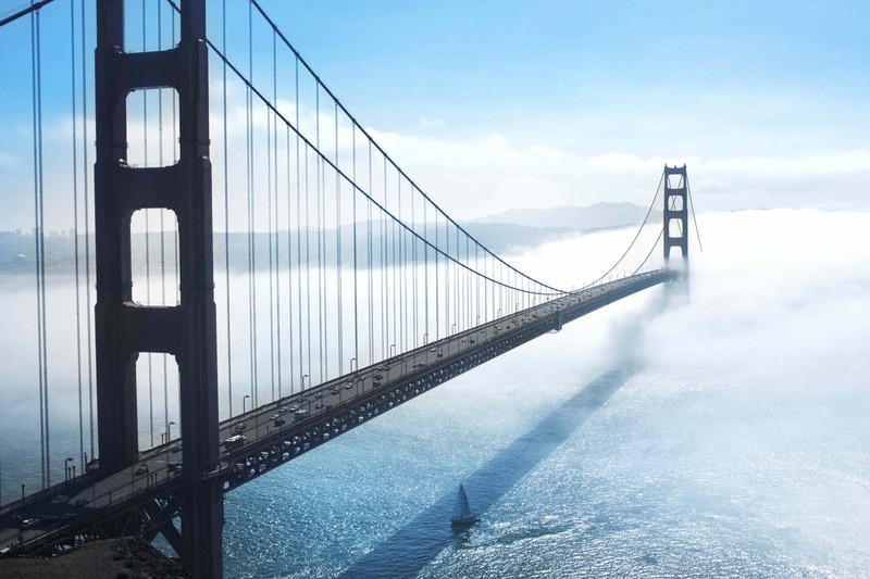 Вид сверху на мост с лодкой, проходящей под ним (мост золотые ворота, golden gate bridge, подвесной мост, мост, вантовый мост)