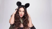 Megan Fox em uma roupa brincalhona com orelhas de rato, exalando confiança e charme.