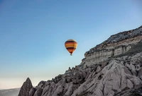 Montgolfière s'élevant au-dessus des paysages uniques de la Cappadoce