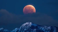 Lua cheia sobre montanhas cobertas de neve