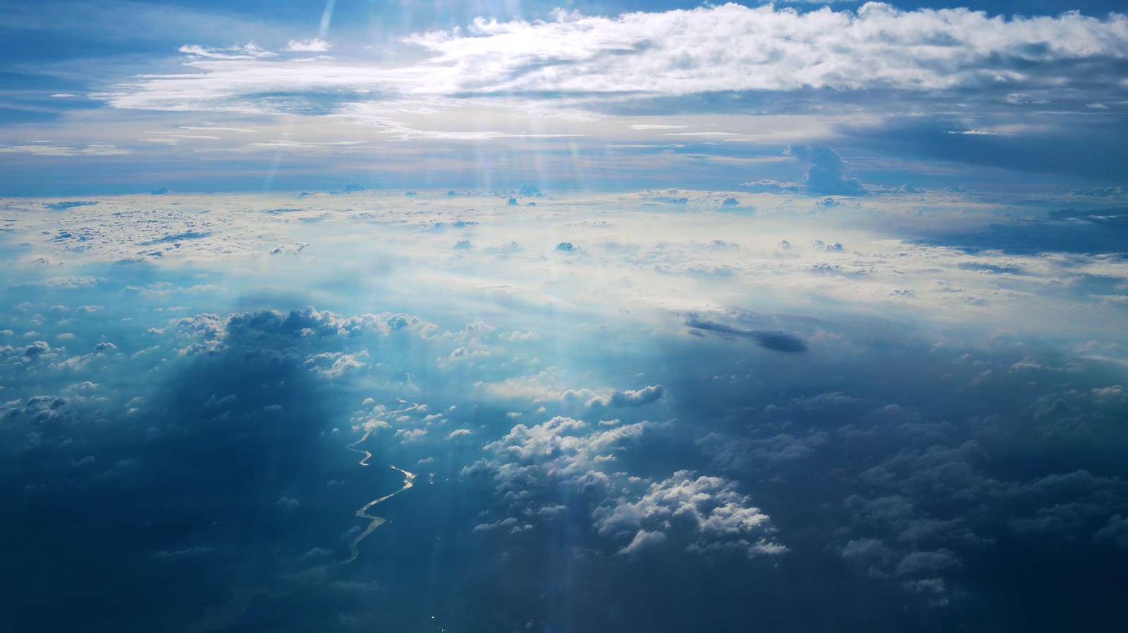 Vue du ciel avec des nuages et le soleil qui perce à travers (atmosphère, nuage, journée, horizon, mer)