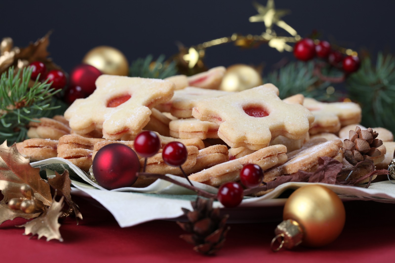 Hay un plato de galletas y decoraciones en una mesa (día de navidad, galleta navideña, postre, pastelería, comida)