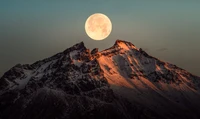 Beleuchtete schneebedeckte Gipfel unter einem Vollmond in Island