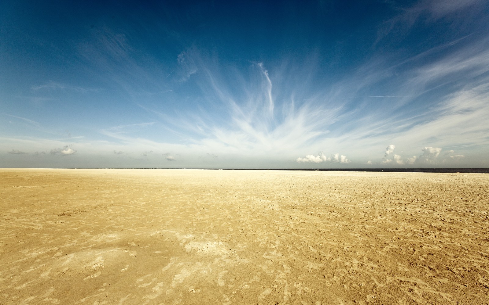 Vue aérienne d'une plage de sable avec un ciel bleu (désert, horizon, mer, journée, nuage)