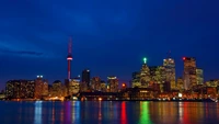 Ligne d'horizon de Toronto la nuit : Une métropole lumineuse avec des reflets sur l'eau