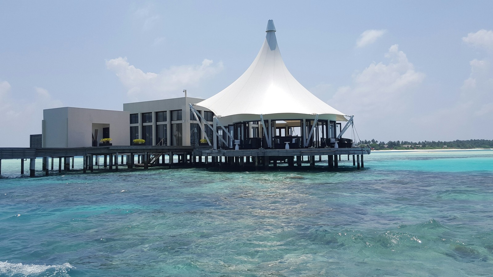 There is a white tent on the pier over the water (sea, swimming pool, vacation, resort, ocean)