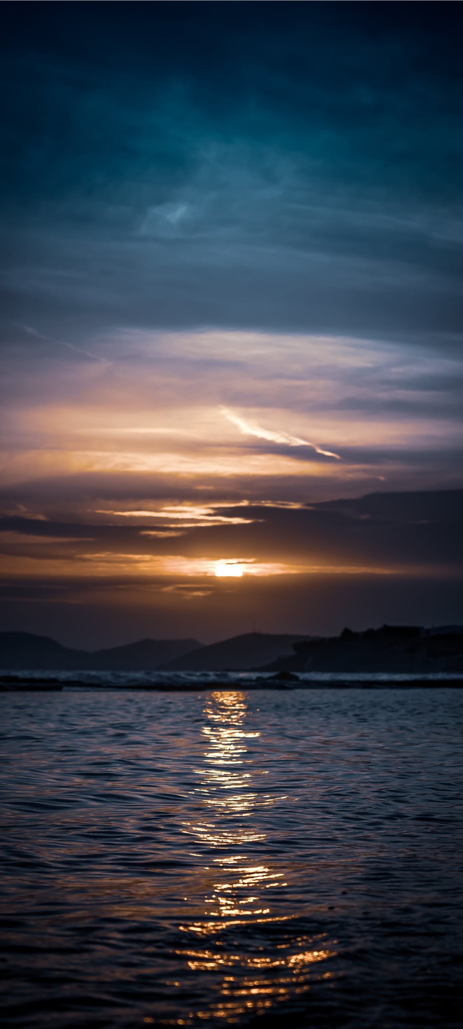 Vista de um pôr do sol sobre o oceano com um pequeno barco na água (ios, água, nuvem, atmosfera, recursos hídricos)