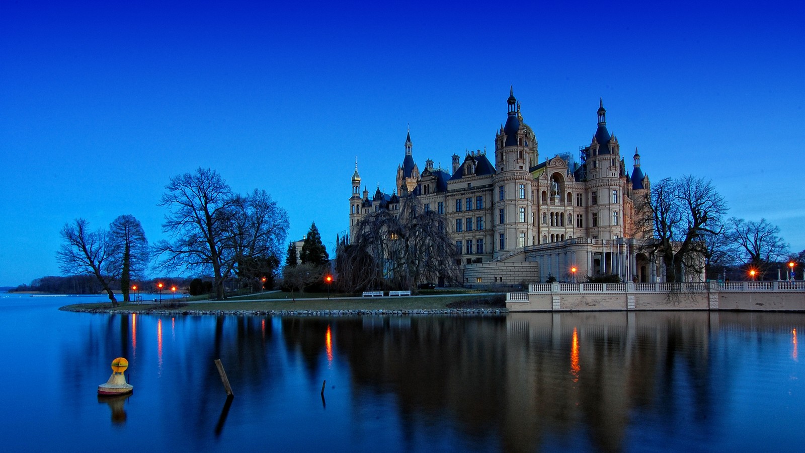 Eine verwilderte sicht auf ein schloss mit einem see und einem boot im vordergrund (burg, palast, reflexion, wasser, wahrzeichen)