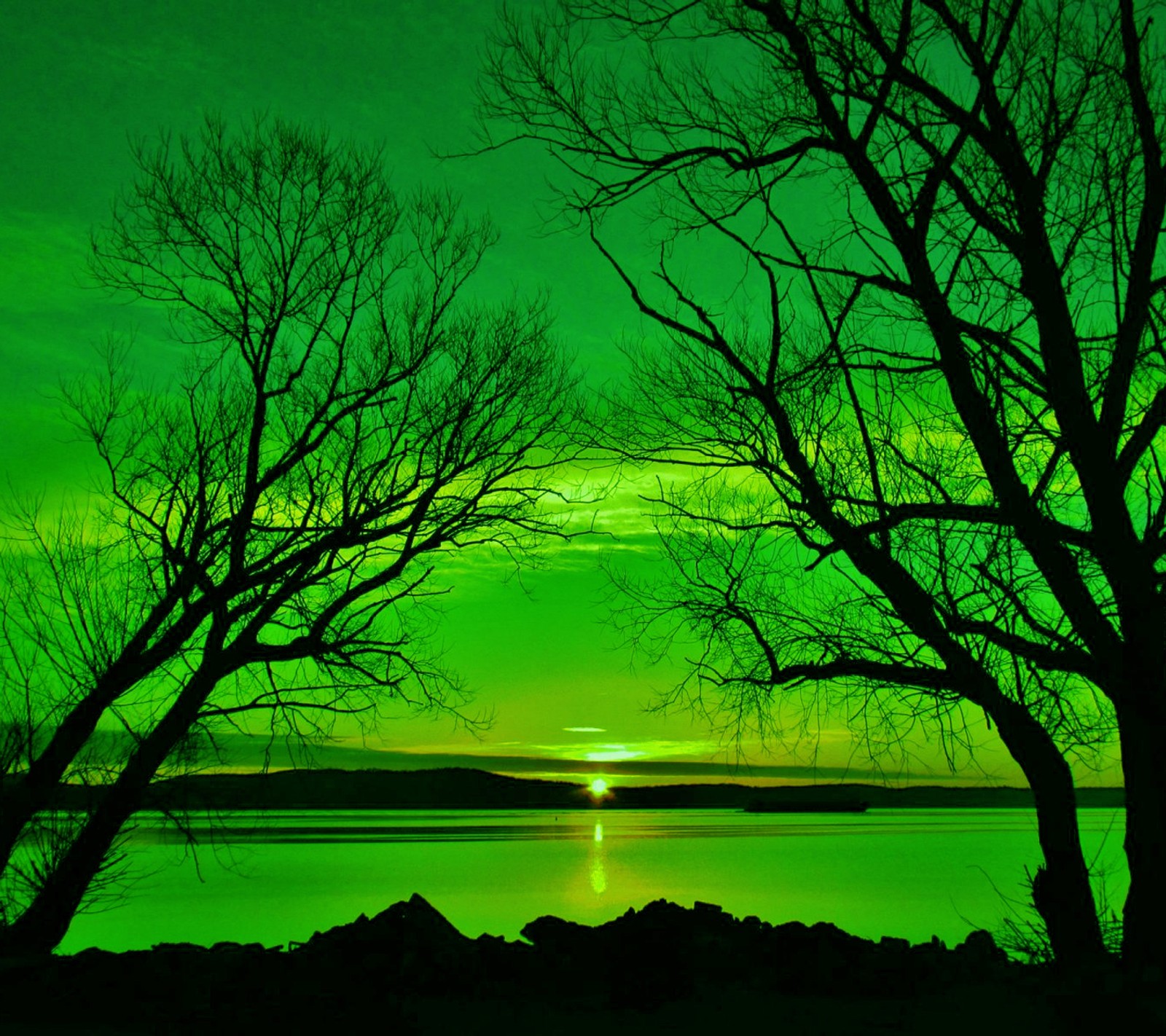 A view of a green sky with a green light in the distance (green, landscape, sunset)