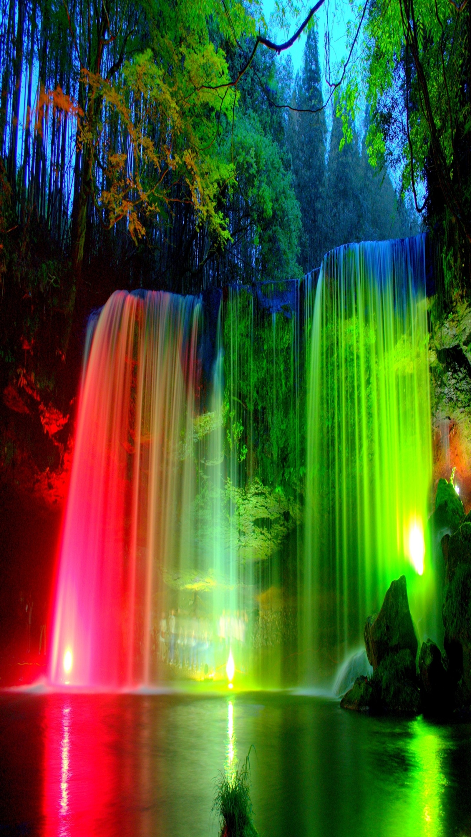 Une cascade avec des lumières colorées au milieu d'une forêt (couleur, forêt, eau, la cascade)