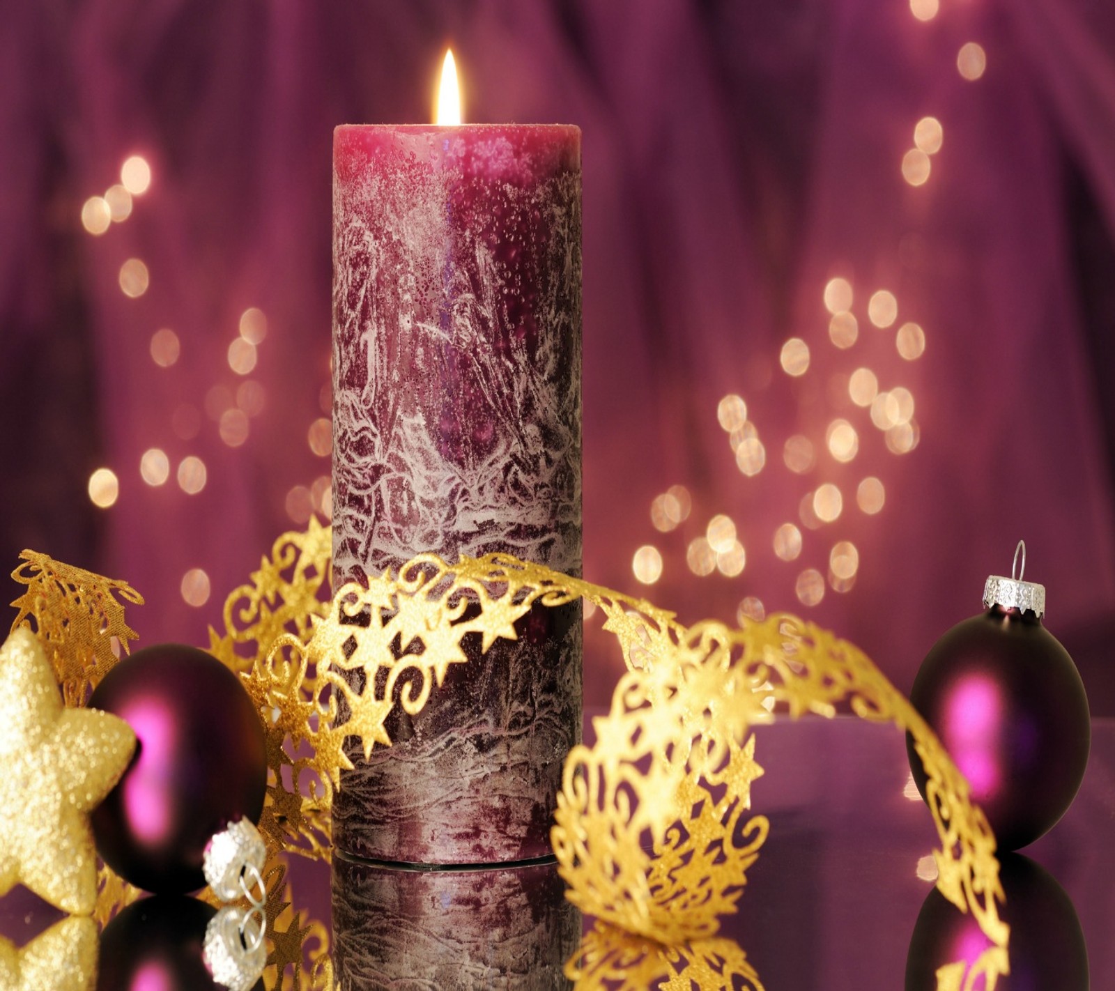 Purple and gold christmas decorations with a lit candle and baubie (christmas, decoration)