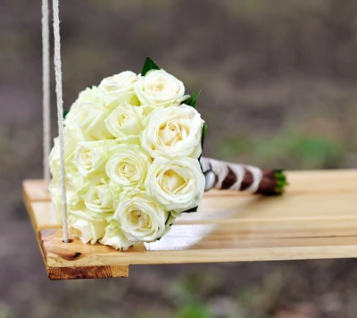 Ramo de rosas blancas elegante en un columpio de madera