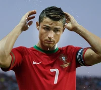 Cristiano Ronaldo com a camisa da seleção nacional de Portugal, focando intensamente com gotas de água caindo ao seu redor.