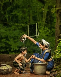 A mother joyfully pouring water for her child amidst a lush green backdrop, symbolizing love and nurturing.